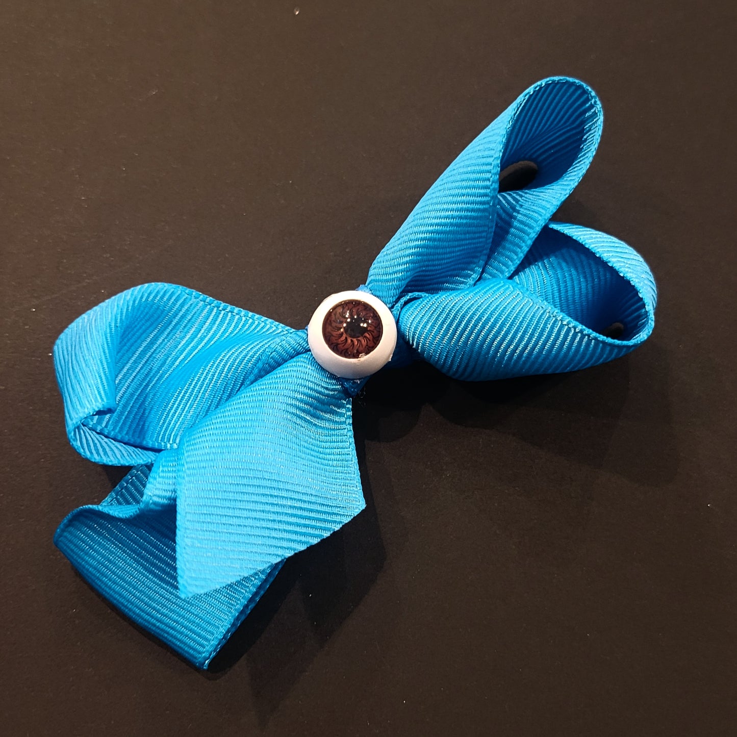 Boucle à cheveux bleue oeil brun